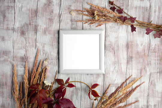 Poster frame autumn mockup. Top view,  Stylish minimal composition with photo frame on rustik white wooden background. Holiday concept. Flat lay. Copy space