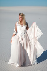 Fototapeta na wymiar Beautiful bride on white sands in the desert 
