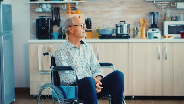Portrait of senior man with disabilities in wheelchair looking depressed. Elderly handicapped pensioner after injury and rehab, paralysis and disability for depressed invalid full of sorrow, worry and