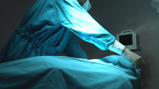 Doctor cover up deceased male patient after failed surgery.