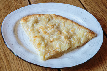 Large piece of pizza with cheese. Hot tortilla with cheese, Khachapuri, Caucasian kitchen.