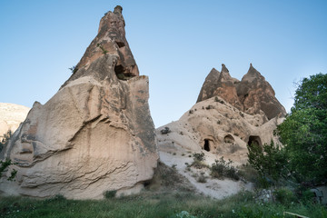 Fototapeta na wymiar Cappadocia fairy chimneys and carved rock houses. Kapadokya is known as one of the best places to fly with hot air balloons worldwide. Goreme, Cappadocia, Turkey.
