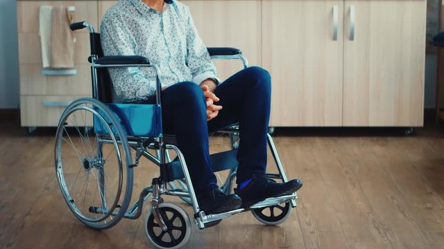Paralysed senior man in wheelchair feeling unhappy. Elderly handicapped pensioner after injury and rehab, paralysis and disability for depressed invalid full of sorrow, worry and sad face. Retirement