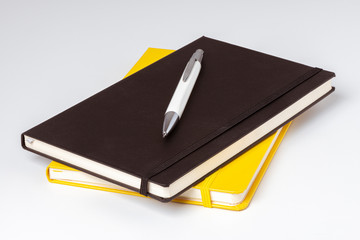 Carnets de note jaune et noir avec un stylo posé