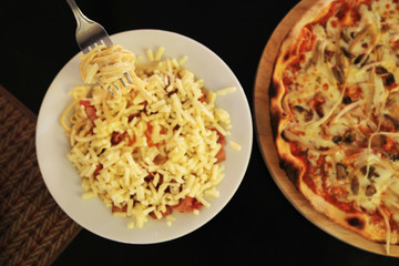 Delicious summer meal: Homemade pizza with mushroom and soft cheese and classic spaghetti carbonara. Top view.