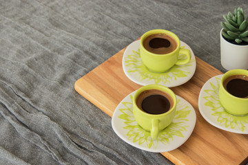 Turkish coffee standing on wooden piece. Gray cover in the background