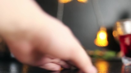 hand launches a cocktail on the bar at the end of the frame