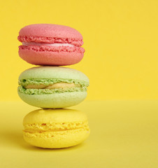 stack of baked macarons on a yellow background, delicious dessert made from almond flour