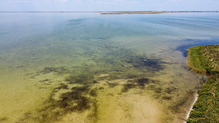 shallow transparent lake with small waves. View from above