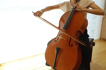 チェロを弾く若い女性　柔らかい光が射す部屋で woman playing the cello