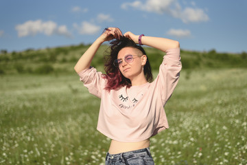 Portrait of beautiful young woman standing in chamomile field.