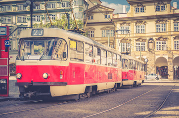 Fototapeta na wymiar Typical old retro vintage tram on tracks near tram stop in the streets of Prague city near Sternberg palace in Lesser Town (Mala Strana) district, Bohemia, Czech Republic. Public transport concept.