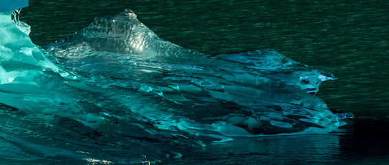Crystal clear iceberg floating in the ocean off the coast of Alaska, USA.