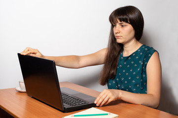 The girl is a freelancer working on a laptop from home. Remote work at the computer. The office of the house. Businesswoman.