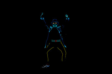Silhouettes of people in glowing suits on a black background. Neon suit. Entertainment. Dancing.