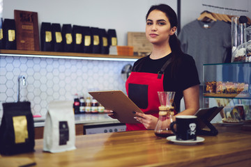 Experienced female barista preparing for revision in coffee shop