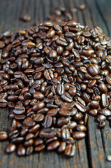 Scattered coffee beans on brown wooden background