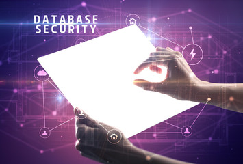 Holding futuristic tablet with DATABASE SECURITY inscription, cyber security concept