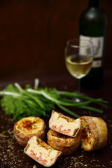 Healthy food with bread, fish, scallion, glass of wine on dark brown background
