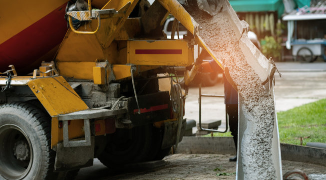 Workers are pouring, concrete and equipment
