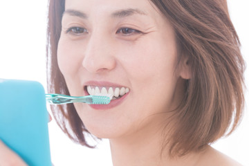 歯磨きをしながらスマホを見る女性