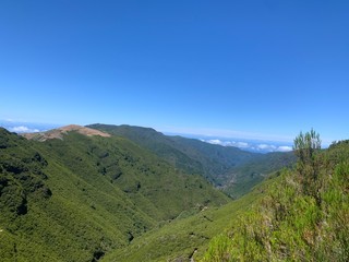 Naklejka premium mountain landscape with blue sky and clouds in levada do alecrim, madeira island