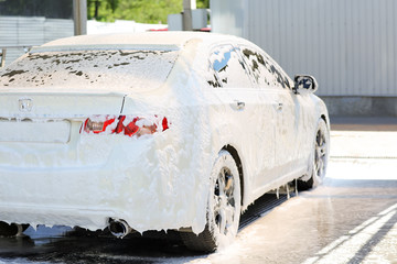 Modern automobile in foam at car wash