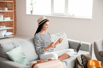 Woman with tablet computer booking tickets online at home