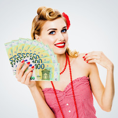 Happy thinking, looking up pinup beautiful woman holding fan of money euro cash banknotes, pin up style. Blond girl in retro and vintage studio concept. Over bright grey background. Square image.