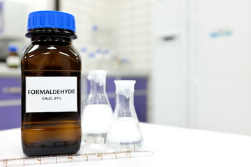 Selective focus of formaldehyde or formalin in brown amber glass bottle inside a laboratory....