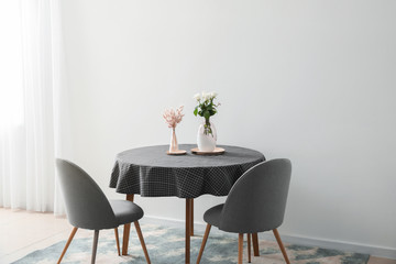 Table and chairs near light wall