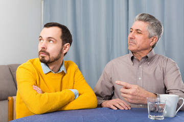 Mature father and son are serious talk and solve family problems at home