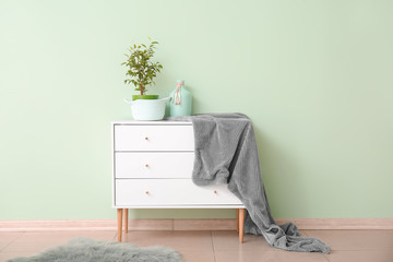 Chest of drawers near stylish mint wall in room