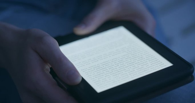 A woman reading an e-book in the evening or by night.