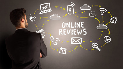 businessman drawing social media icons with ONLINE REVIEWS inscription, new media concept