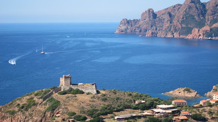Malerische Bucht in der Calanche auf Korsika mit Burg im Vordergrund 