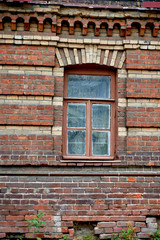 An old brick house with old masonry and windows.An old crumbling factory.