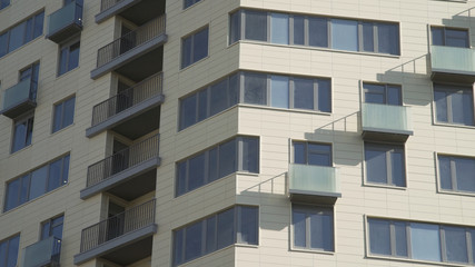 Exterior establishing shot of a New York style apartment building during the day. Windows and the brick facade