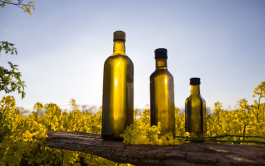 Set bottle of rapeseeds oil and blooming yellow canola