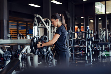 Fototapeta na wymiar Fitness girl exercising with barbell in gym.