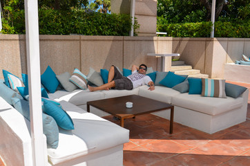Homem relaxando deitado em local aconchegante