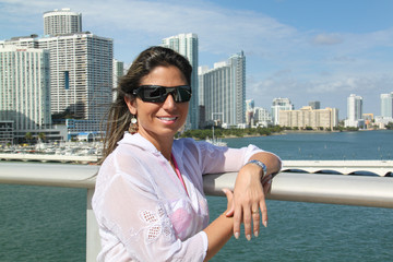 Fototapeta na wymiar Retrato de uma bonita mulher brasileira em praia da Flórida. Usando biquini e óculos escuros. Lindo sorriso. Muito feliz. 