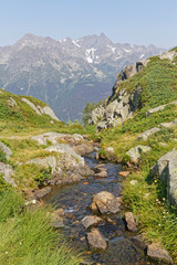 Obraz premium A small river over the cliffs and Belledonne in the background