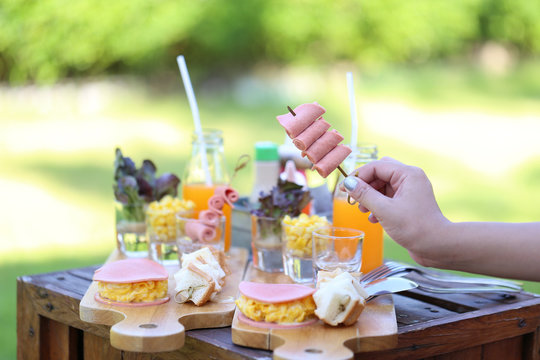 Selective focuse of Woman hand holding borona ham made from pork with breakfast on table in the morning for two at the luxury hotel