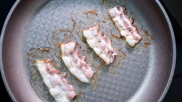 Time lapse bacon slice in a pan