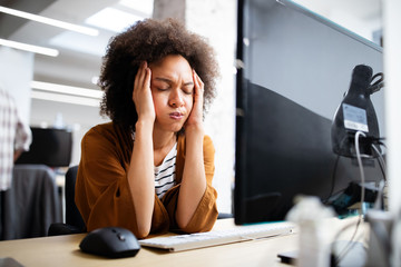 Overworked and frustrated young woman in front of computer in office