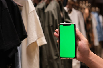 close up hand showing green screen smart phone in clothing shop