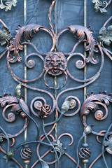 iron door with black forged lattice with a handle in the form of a lion's head