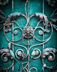 iron door with black forged lattice with a handle in the form of a lion's head