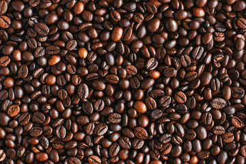Top view of roasted aromatic coffee beans, which will then be used to prepare an invigorating coffee drink. An ingredient for espresso.
